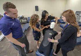 Palmer students practicing technique on a dummy.