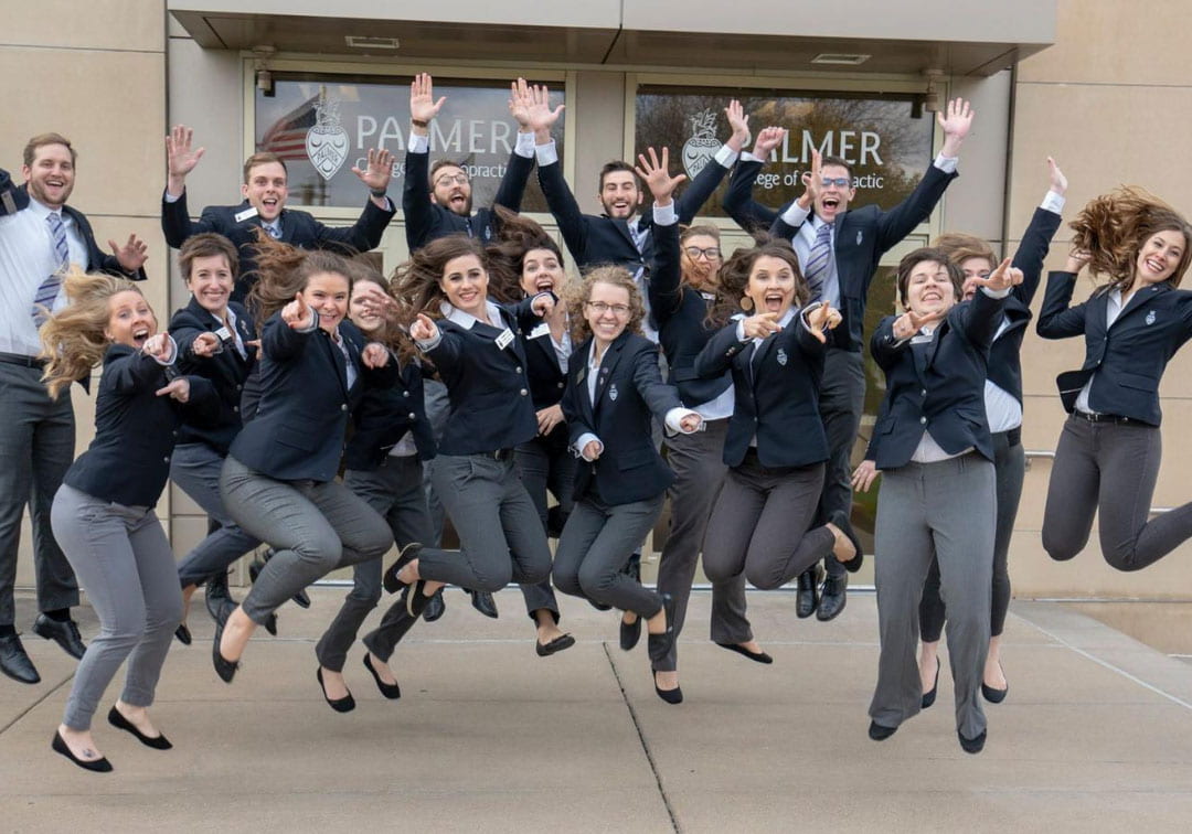 Group photo of Palmer campus guides jumping in the air.