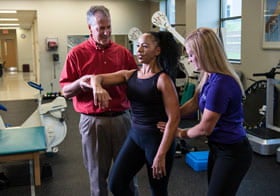 Palmer Clinic rehab faculty and student working with patient.