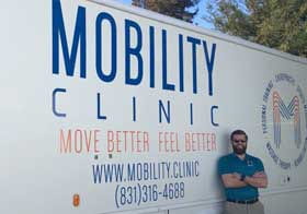 Brandon Thomas, D.C., in front of Mobility Clinic vehicle