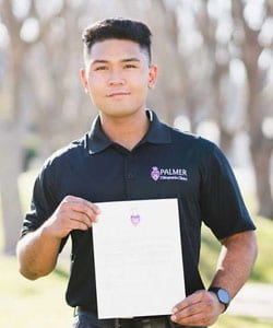 Shawn Ramos holding Palmer College letter.