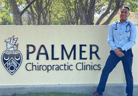 Oscar Campos, Palmer West student, smiling in front of Clinics sign.