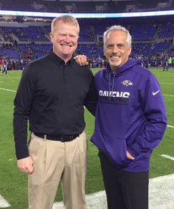 Dr. Greg Kempf (left) with friend staying in Ravens football field.