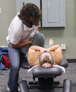 Drew McClure, D.C. showing an adjustment technique on a student patient.