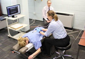 Technician using ultrasound on patient's back for research