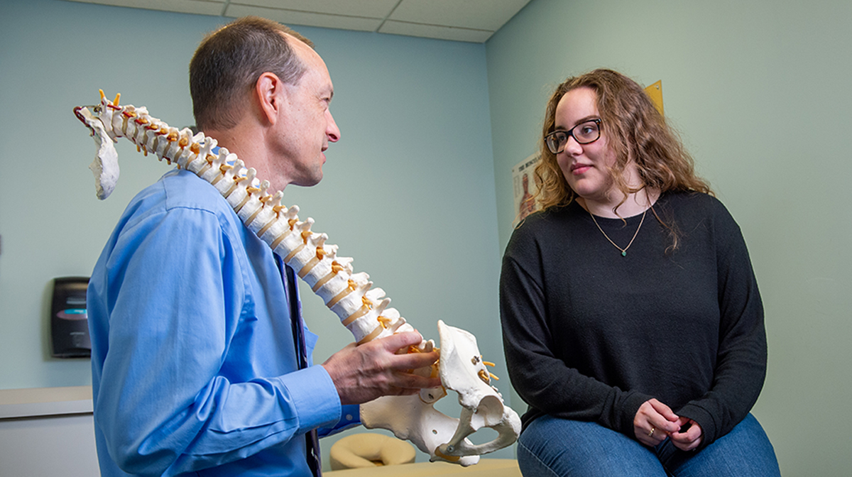 Palmer researcher explains spine anatomy to a patient.