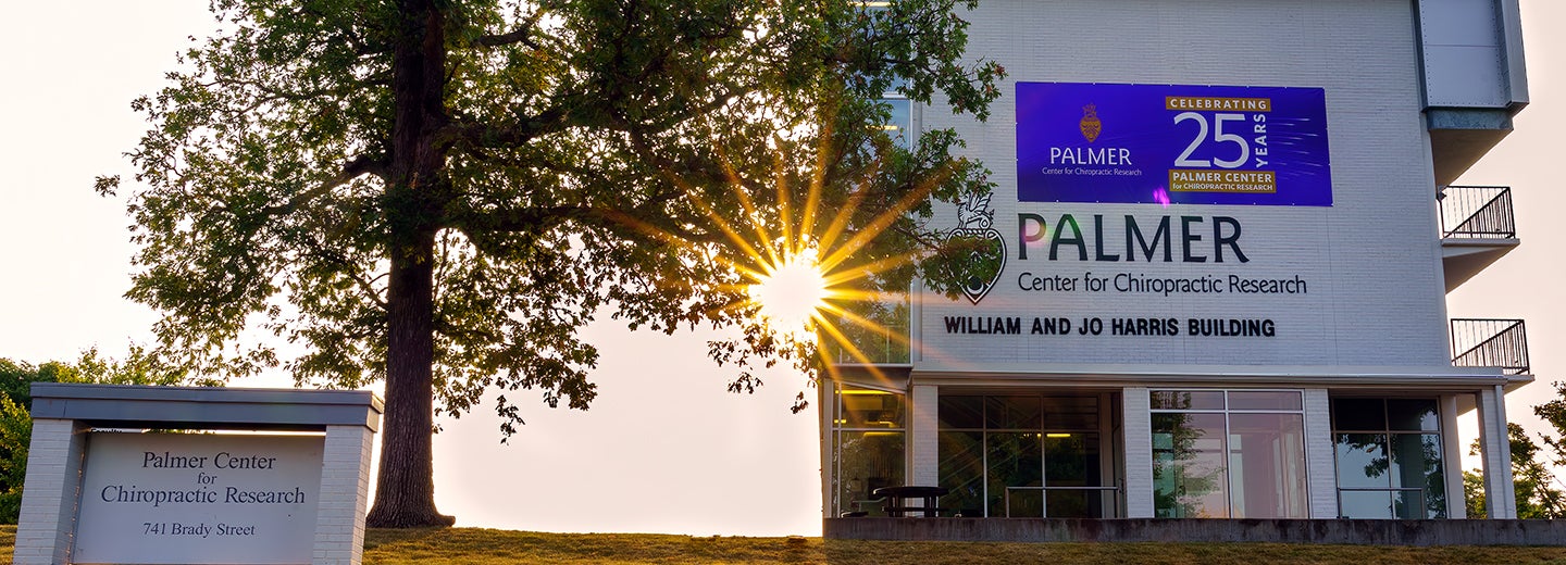 Palmer Center for Chiropractic Research building with sunrise in the background.