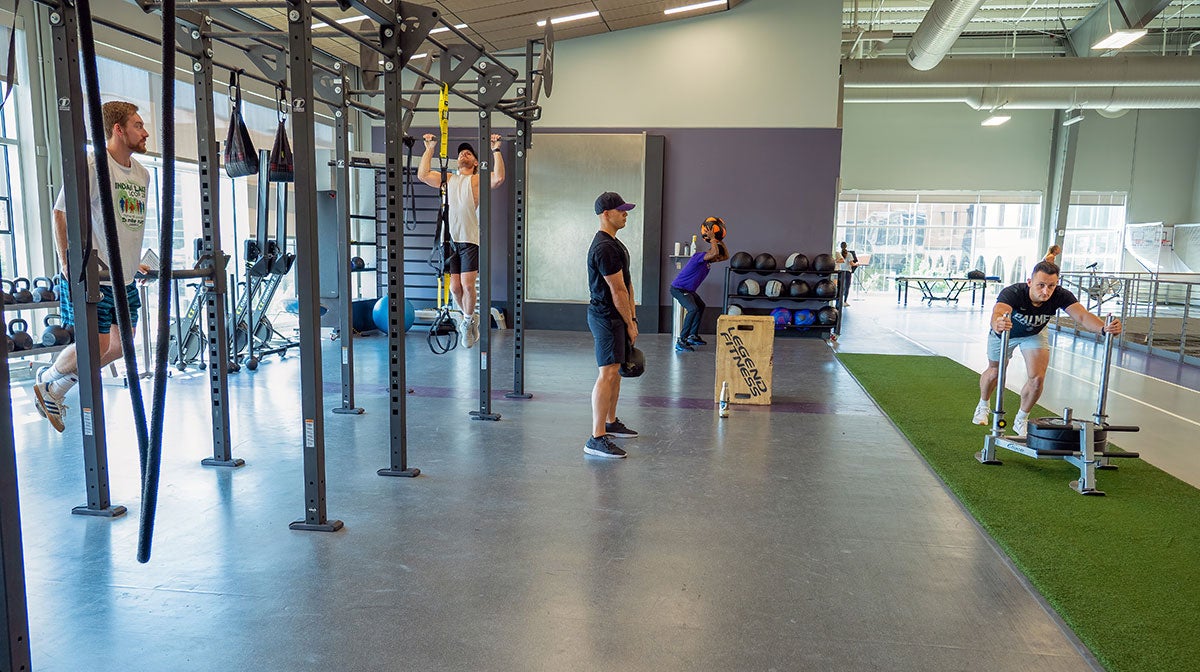 Multiple students exercise in indoor exercise area.