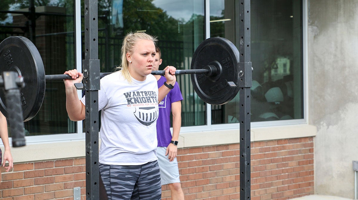 Woman lifting weights outside.