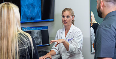 Chiropractor with patients reviewing X-ray images