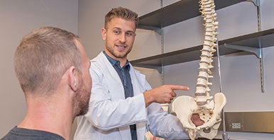 Doctor pointing to spine model.