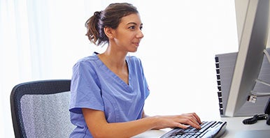 Person sitting and looking at a computer.