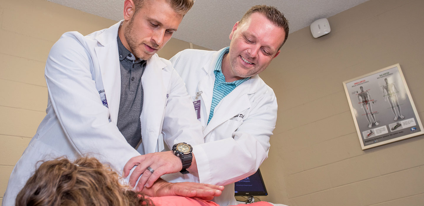 Chiropractor and student intern adjusting a patient
