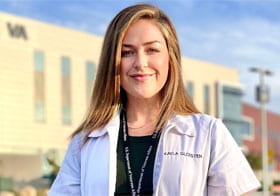 Kayla Gloisten in white clinic coat in front of Palmer building.