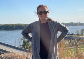 Kate McKenzie, Palmer Main student, in front of river and bridge.