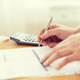 hands with paperwork and calculator