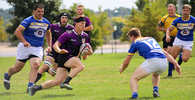 Palmer men's rugby players running with ball.