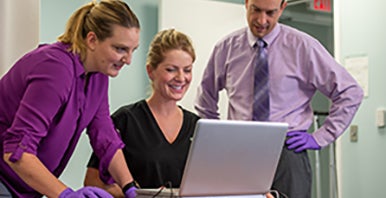 Three researchers at a computer.