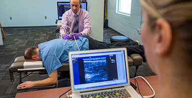 Chiropractic researcher performing an ultrasound study on a patient.