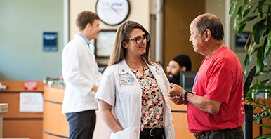 Chiropractic student intern greeting a patient in the clinic.