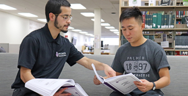 Two students reviewing study material in the Palmer Library.