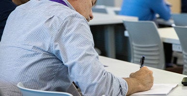 Man sitting at a desk writing.