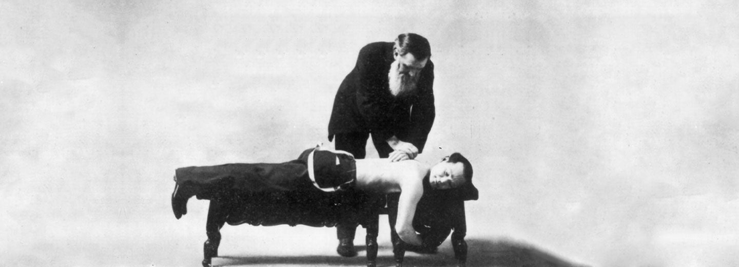 Historical portrait of D.D. Palmer adjusting a man's back.