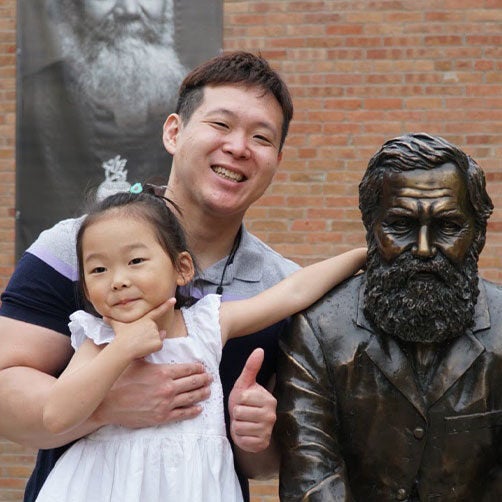 Kilbo Yun and daughter posing with the First Adjustment Statue.