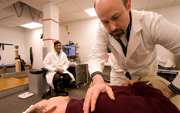 chiropractic researcher performing a back adjustment