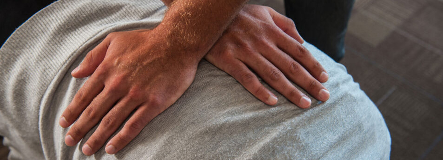 close up of hands on a patient's back.