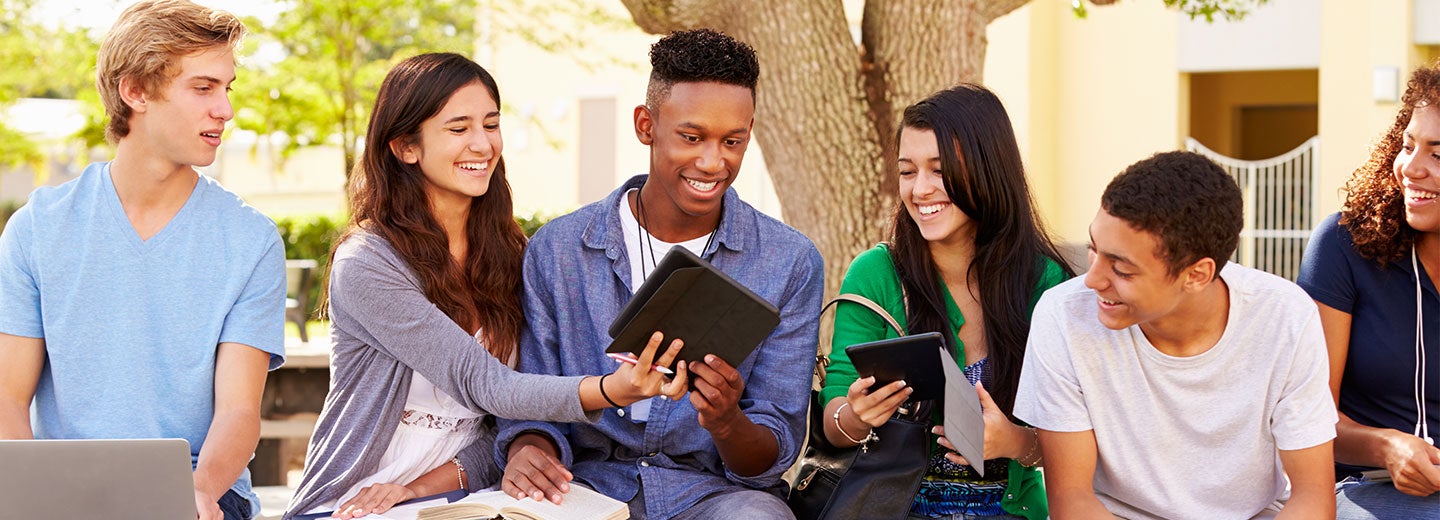 Group of high school students studying with ipads.