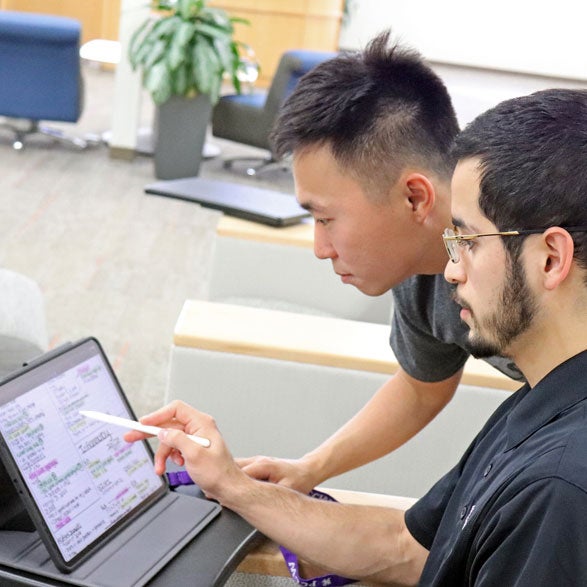 Two students reviewing class notes on iPad