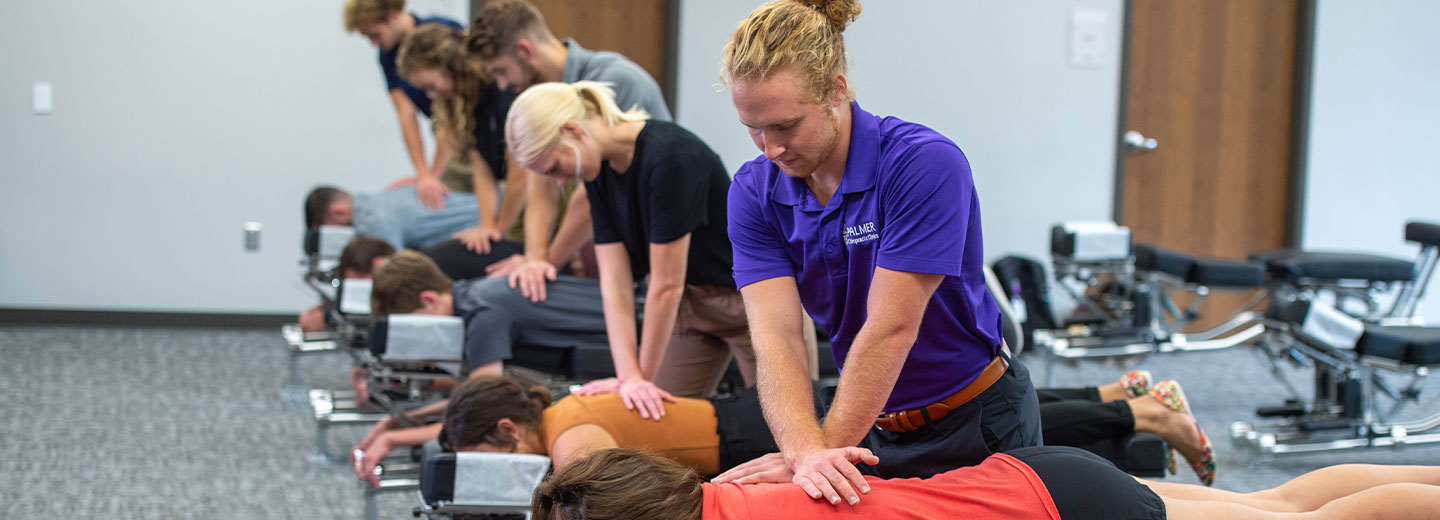 Chiropractic students practicing adjustment technique in class.