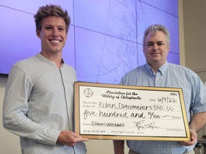 Robin Ostermeiers and Dr. Hynes with award check.