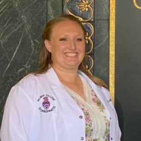 Caitlin Walker smiling in white clinic coat