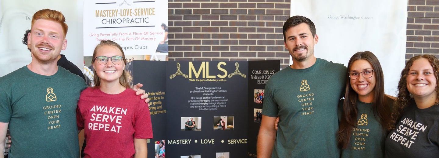 Members of MLS club with board on Main Campus during Club Fest.