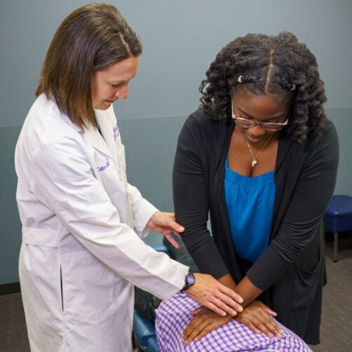 Dr. Dittmar and student adjusting patient's back