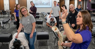 Technique students observing faculty instructor's hand movement.