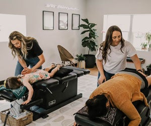 Felicia Devine, D.C. (Main, ’1920) and Taylor Sandin, D.C. (Main, ’21) adjusting patients on table.