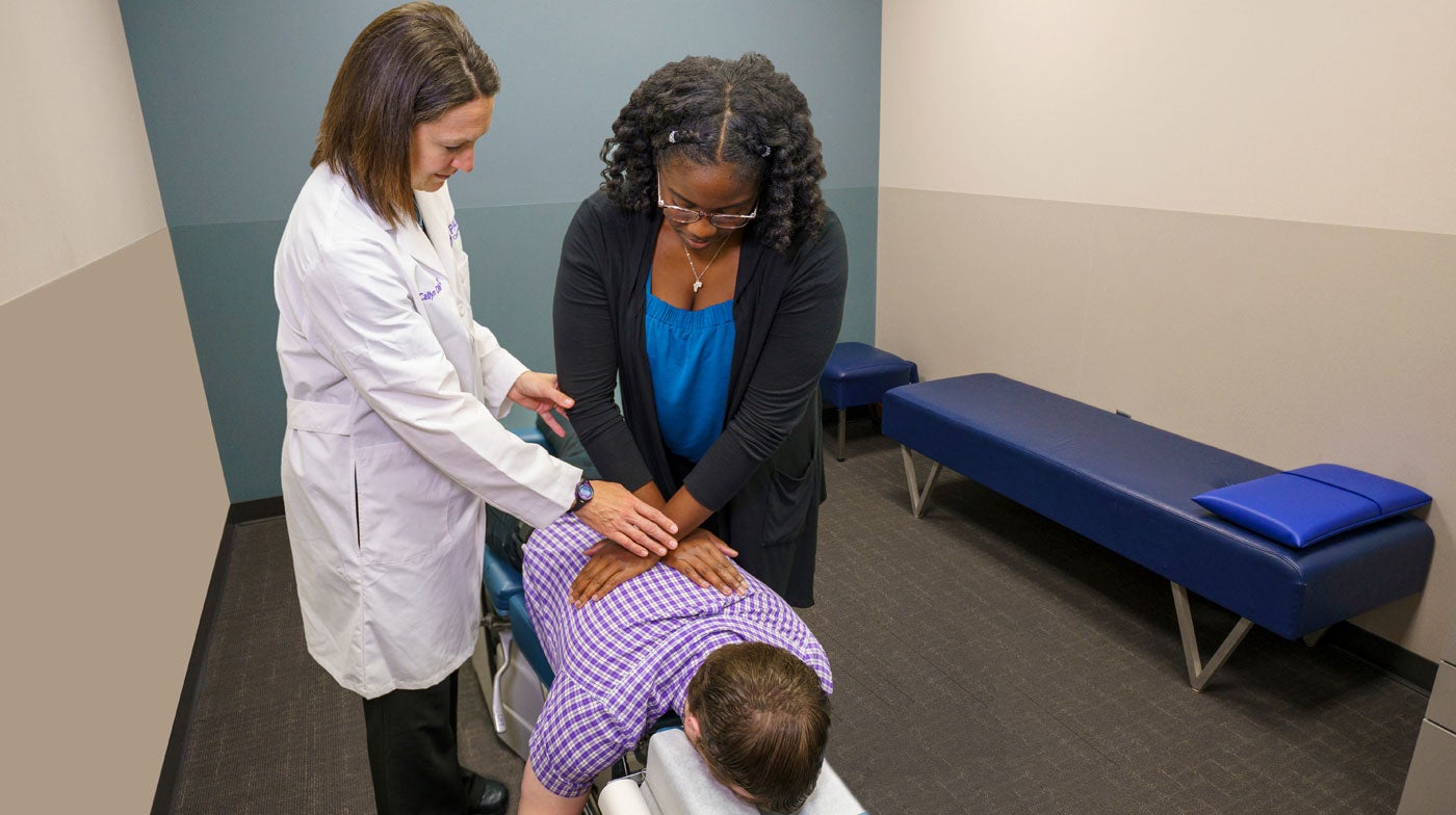 Dr. Dittmar and student adjusting patient's back