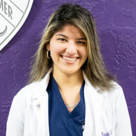 Palmer Florida student Monyia Barakat in white clinic coat.