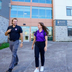 Two students walking outside of VanDuyne Hall.