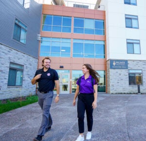 Two students walking outside of VanDuyne Hall.