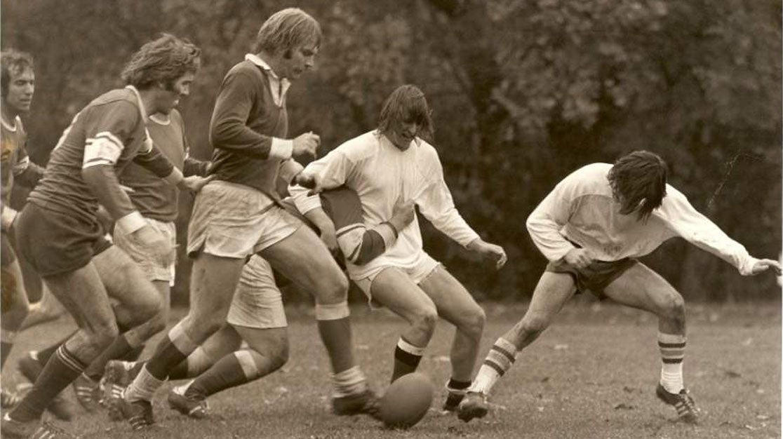 Black and white historical photo of Palmer rugby players outdoors.