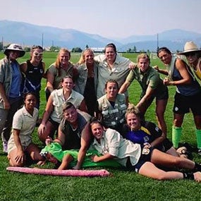 Group of people outside with skyline of mountains in background.