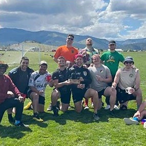 Group of people outside with skyline of mountains in background.