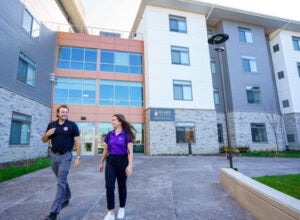 Two students talking outside of VanDuyne Hall.