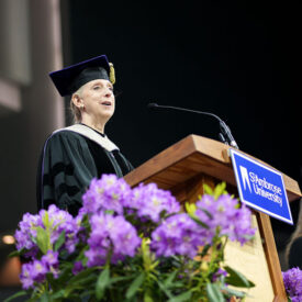 Dr. Lisa Killinger speaking at St. Ambrose commencement podium.
