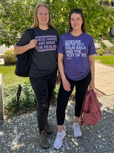 Two students outdoors with backpacks wearing Palmer shirts. 