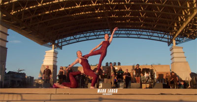 3 AcroYoga performers on outdoor stage.
